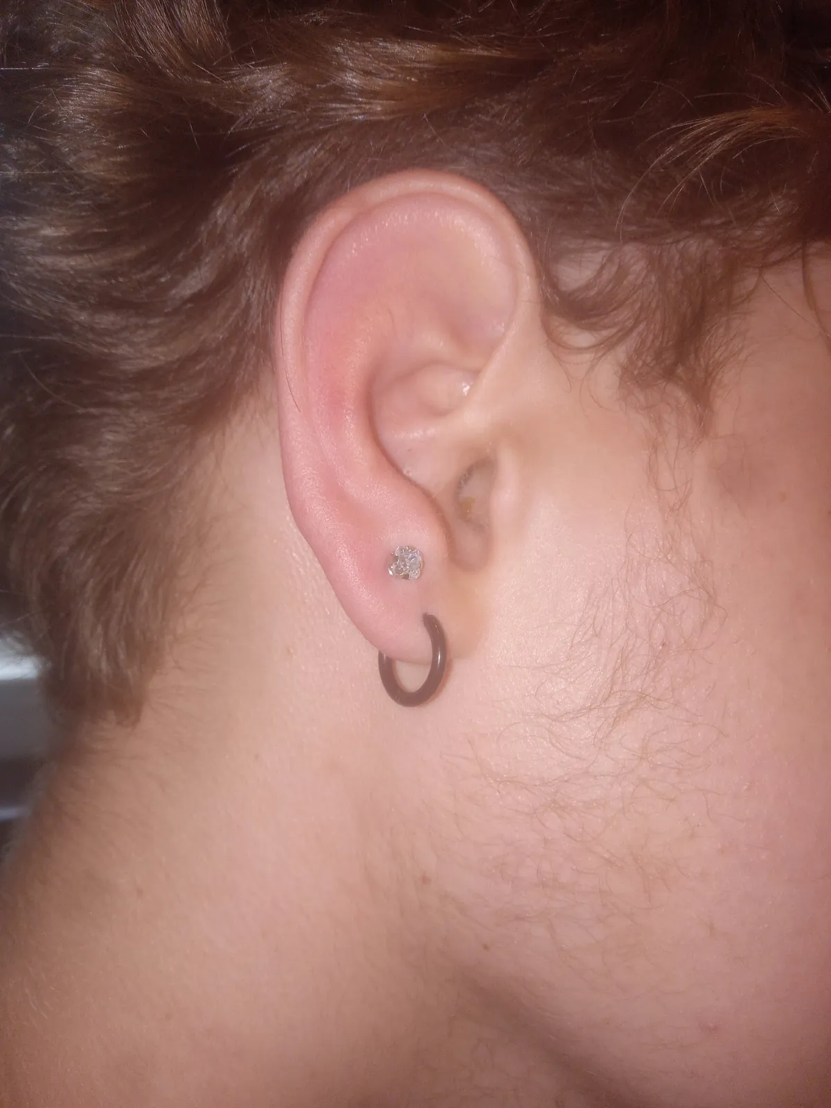 Close-up of an ear with a small hoop and stud