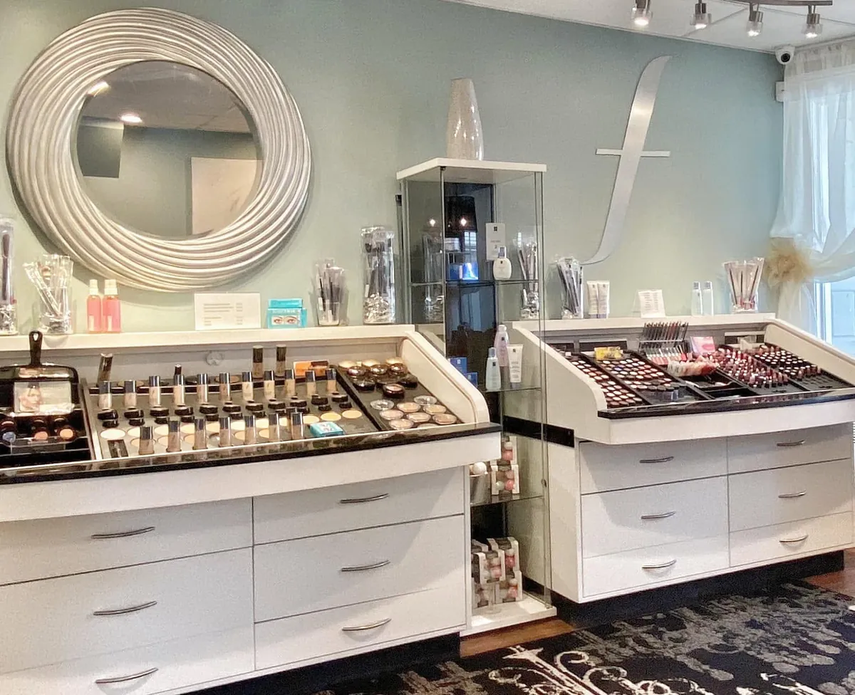 Renew You makeup counter with white drawers, round mirror and pale teal wall