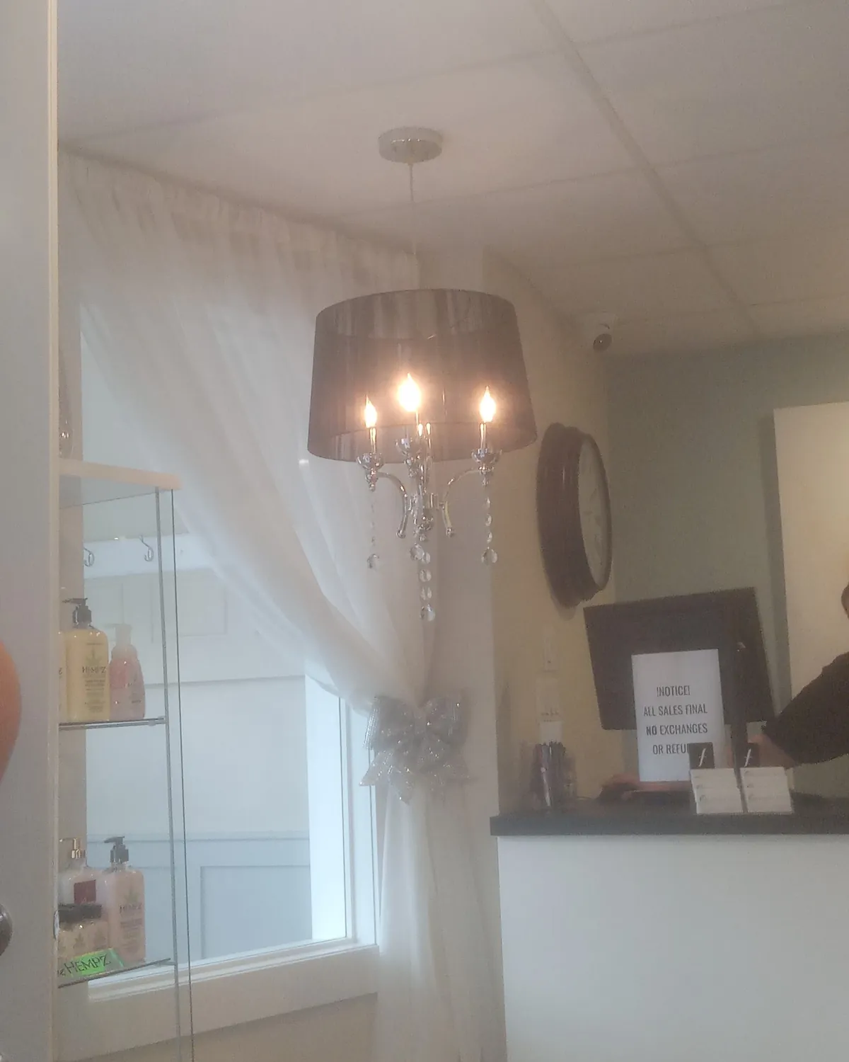 Renew You reception with a chandelier, white curtain and glass shelf